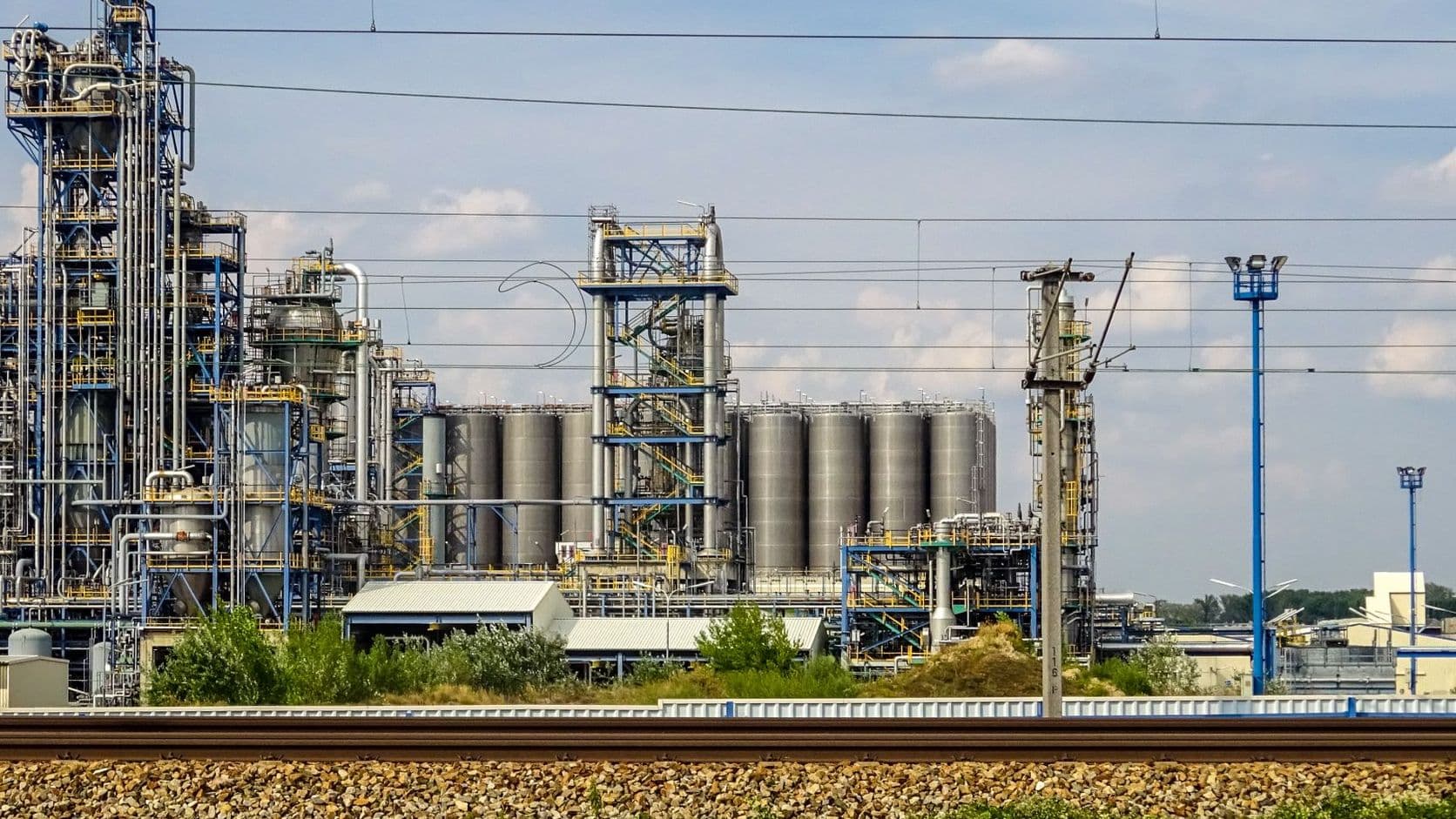 Chemical plant towers, pipework and storage tanks under a blue sky
